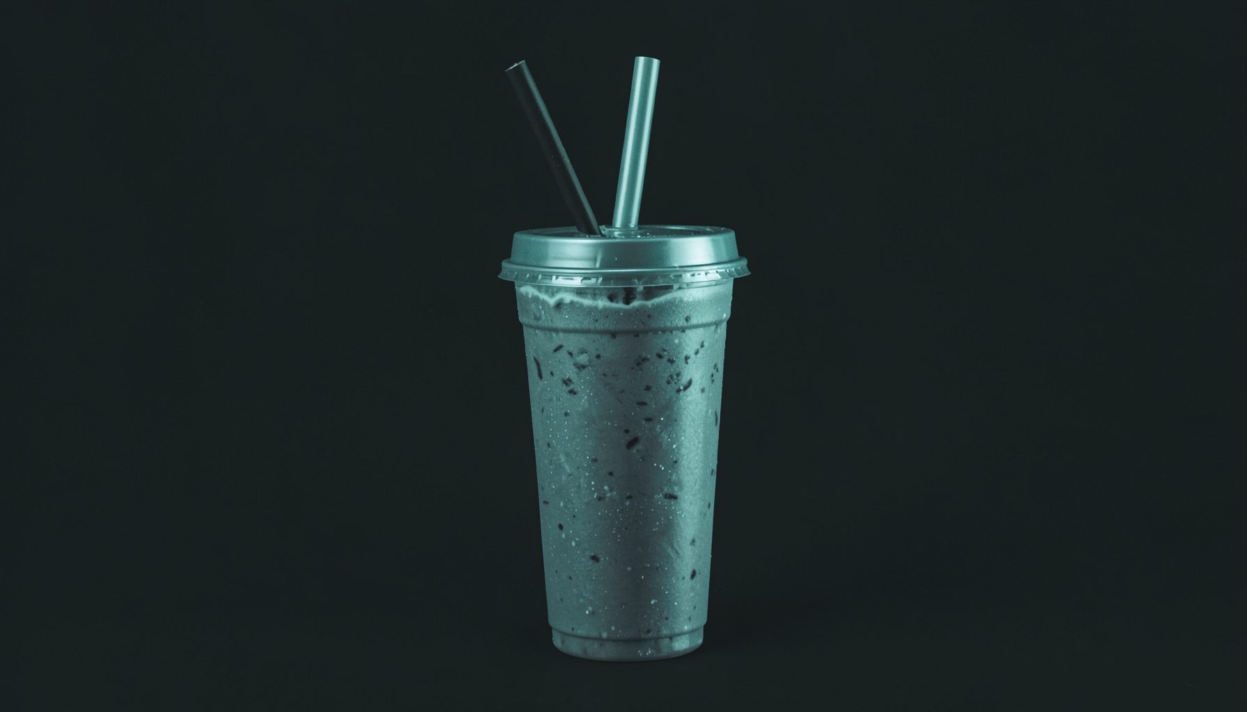 Duotone photograph of a ready-to-drink shake bottle with a straw, clean dark background