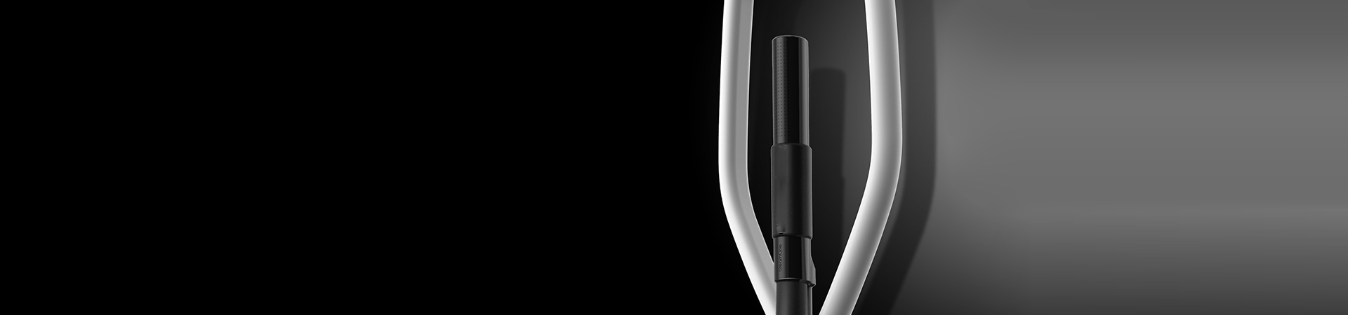 Hard two-tone duotone photograph of a black cylindrical object with a curved light loop against a dark background, monochrome mood, soft contrast.